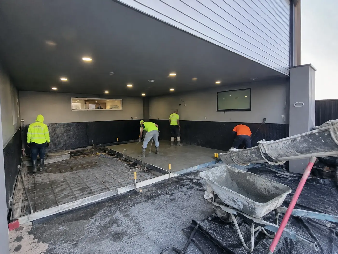 Concreters pouring and screeding a commercial floor slab in Wollongong