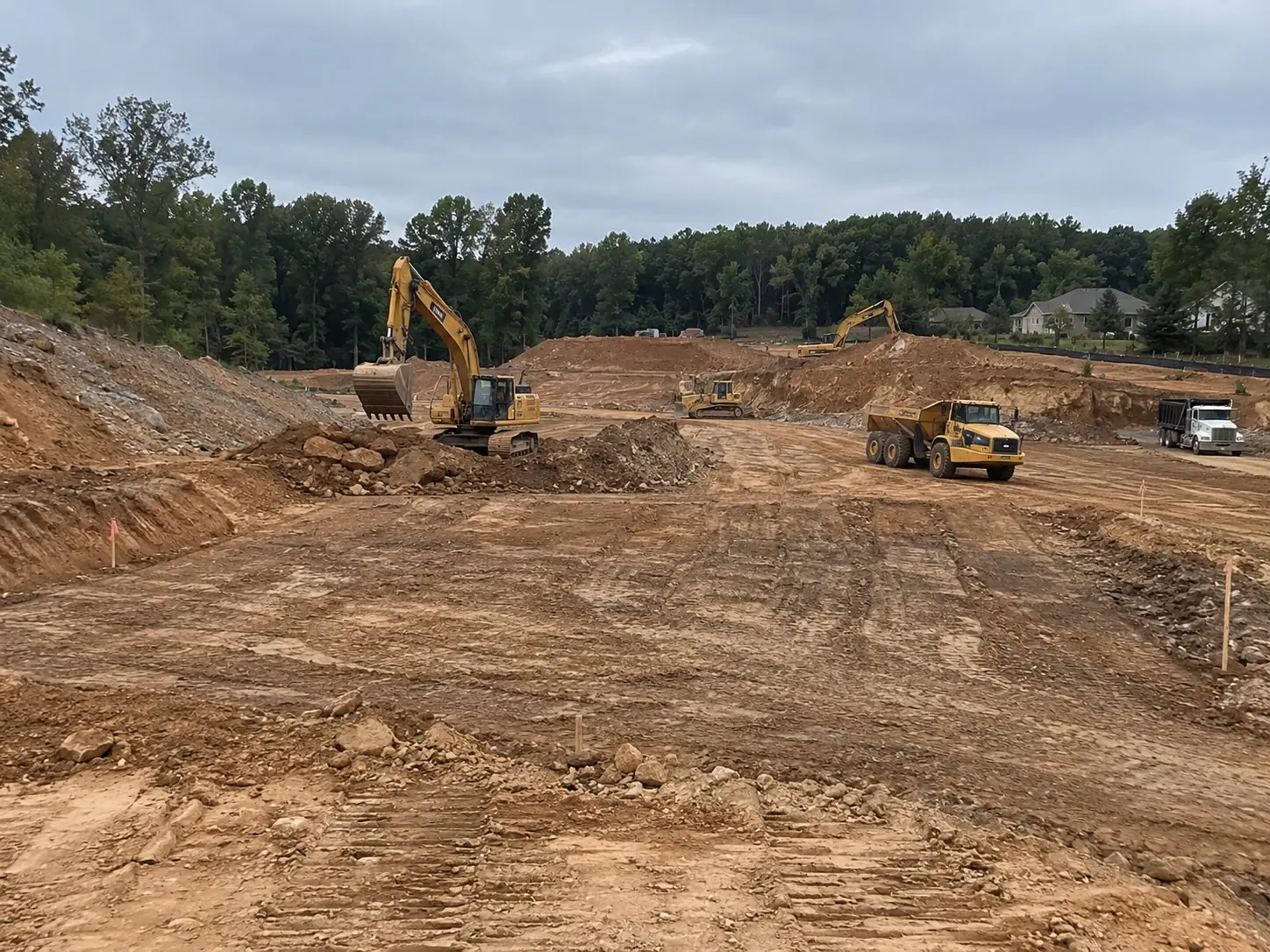 Excavators and dump trucks carrying out bulk earthworks on a large site