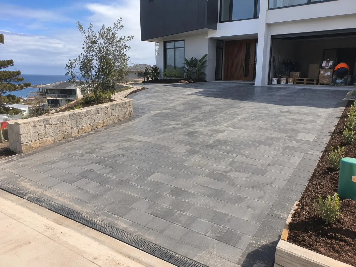 Paved concrete driveway leading to a modern home with ocean views