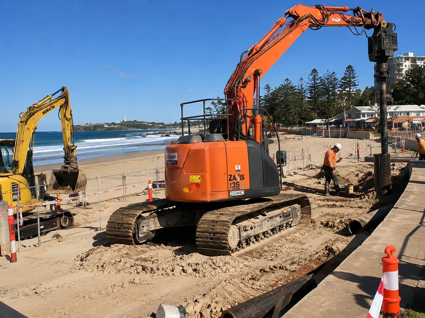 Machinery working on a beachfront seawall behind the sand in Wollongong